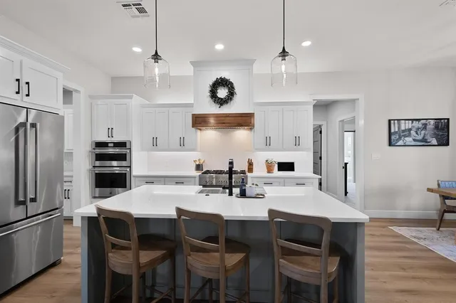 a kitchen with white cabinets and stainless steel appliances