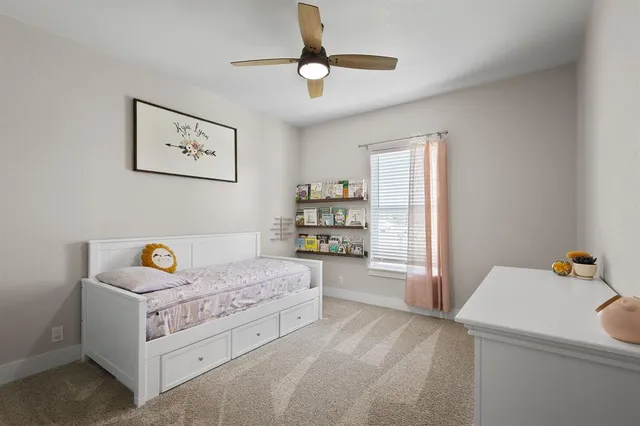 a bed sitting in a bedroom next to a window