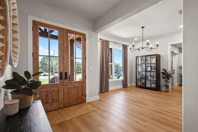 a living room with furniture large window and wooden floor