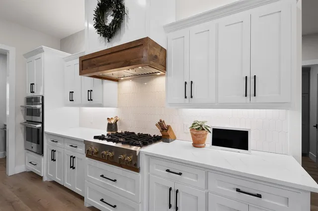 a kitchen with stainless steel appliances a cabinets and a stove top oven
