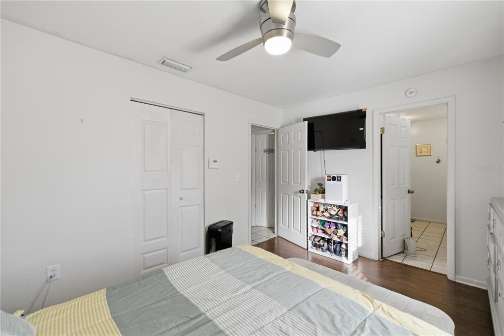 1939 Southwest 73rd Terrace Gainesville, FL 32607 - Photo 16 of 26 a bedroom with a bed and a flat tv screen on wall