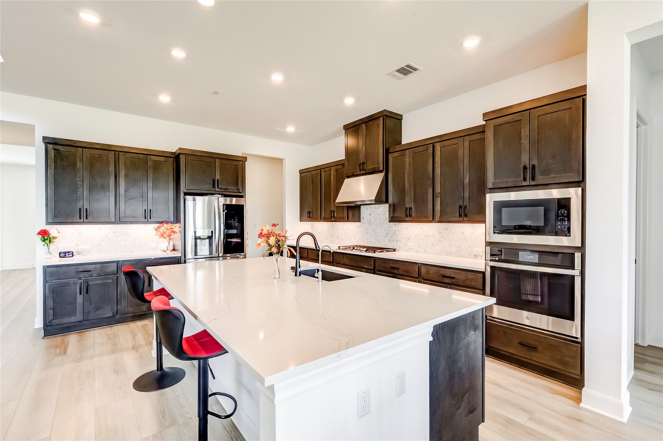 462 Old Stone Road Austin, TX 78737 - Photo 13 of 39 Kitchen featuring tasteful backsplash, stainless steel appliances, a large island, light wood-type flooring, and recessed lighting
