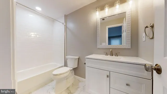 a bathroom with a sink toilet vanity and shower