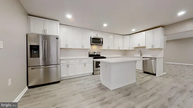 a kitchen with white cabinets and stainless steel appliances