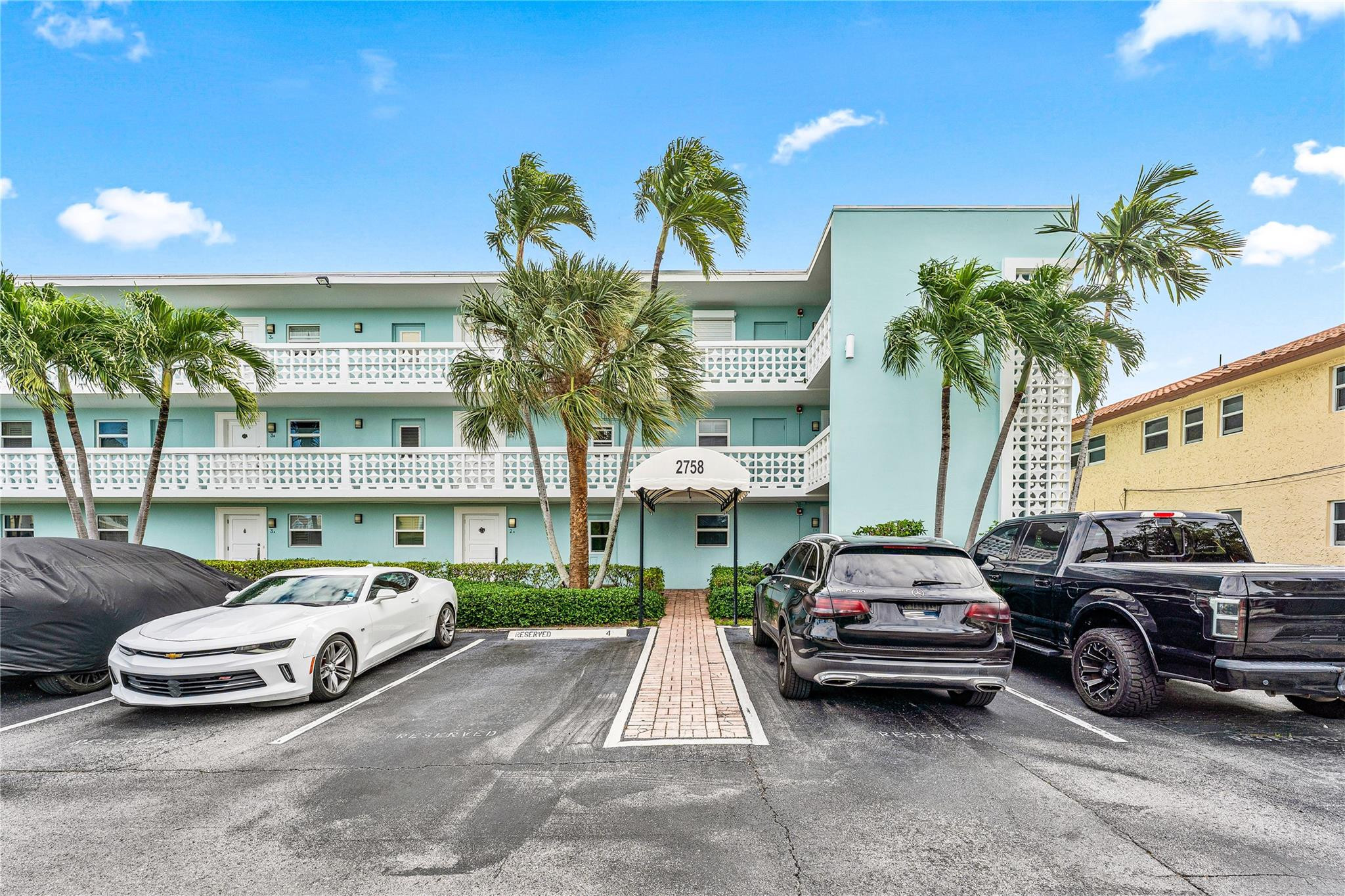 2758 Northeast 30th Avenue, Unit 1A Lighthouse Point, FL 33064 - Photo 22 of 48 a view of a cars parked in front of a building
