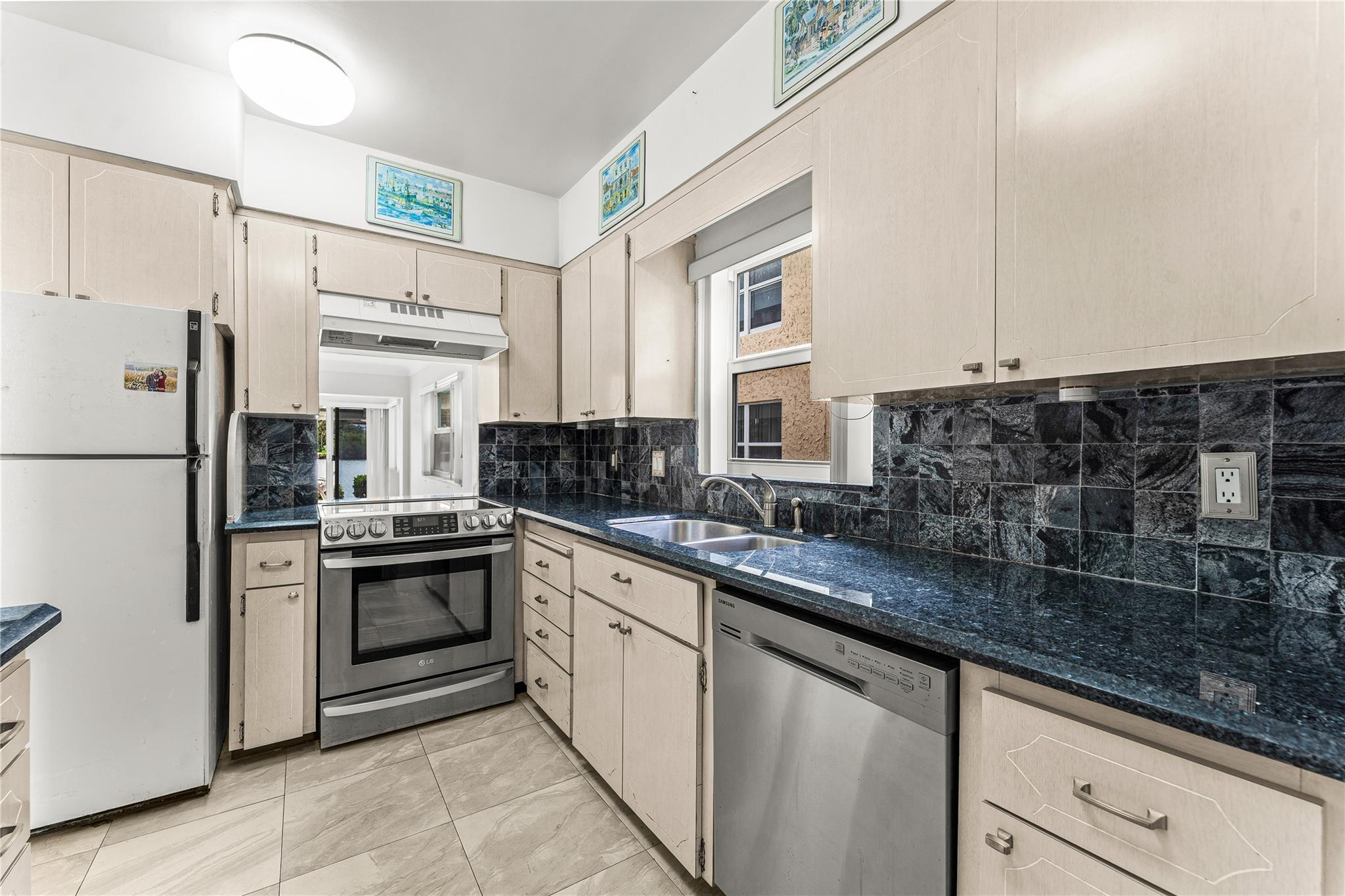 2758 Northeast 30th Avenue, Unit 1A Lighthouse Point, FL 33064 - Photo 24 of 48 a kitchen with stainless steel appliances granite countertop a sink stove and refrigerator