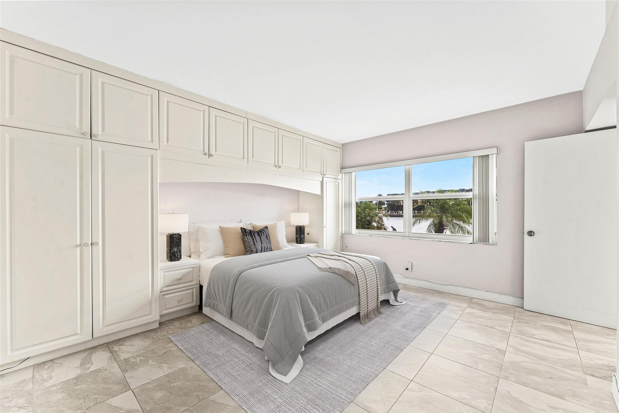 2758 Northeast 30th Avenue, Unit 1A Lighthouse Point, FL 33064 - Photo 33 of 48 a bedroom with a bed a table and painting