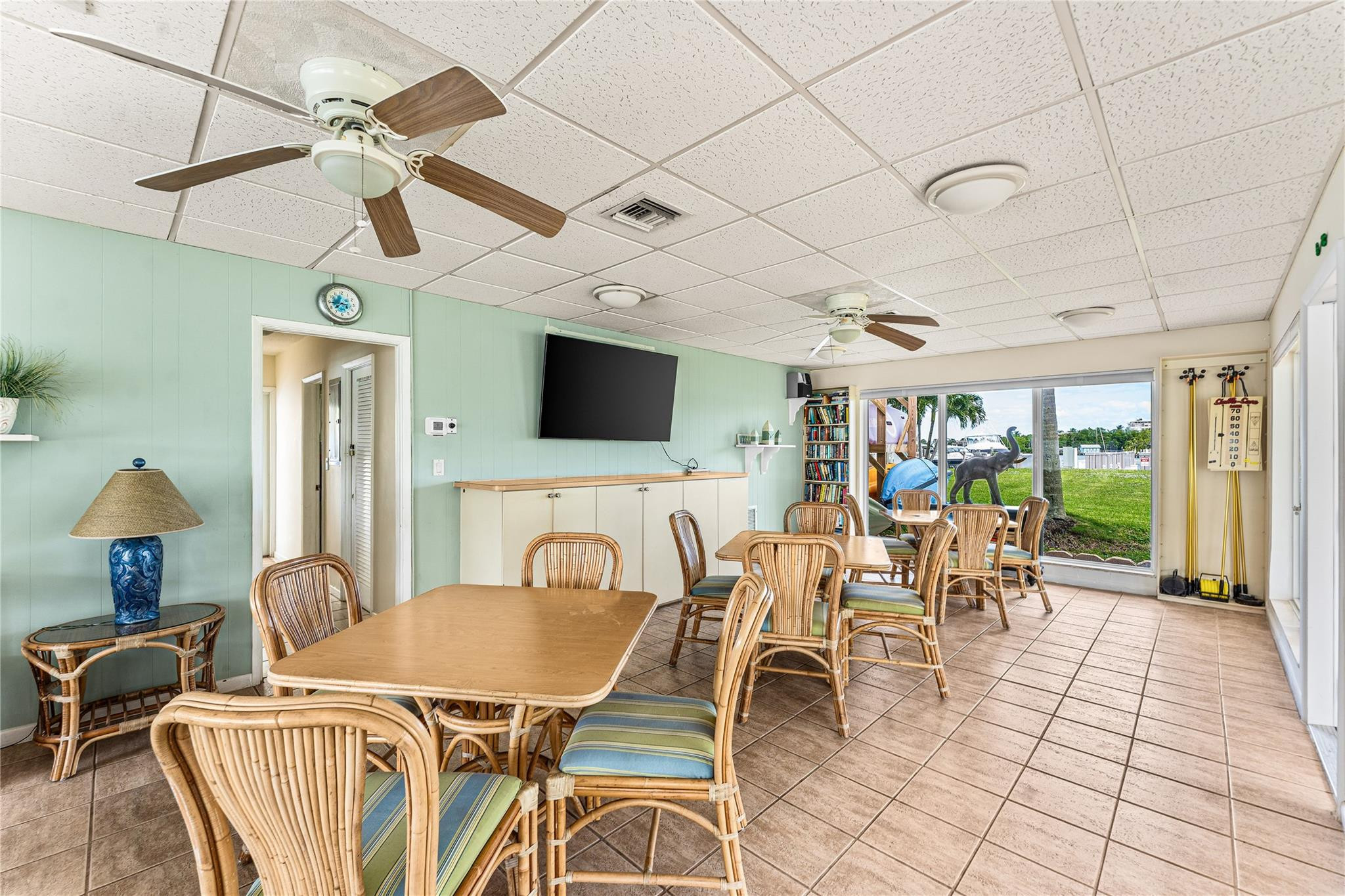 2758 Northeast 30th Avenue, Unit 1A Lighthouse Point, FL 33064 - Photo 46 of 48 a dining room with furniture a flat screen tv and a chandelier