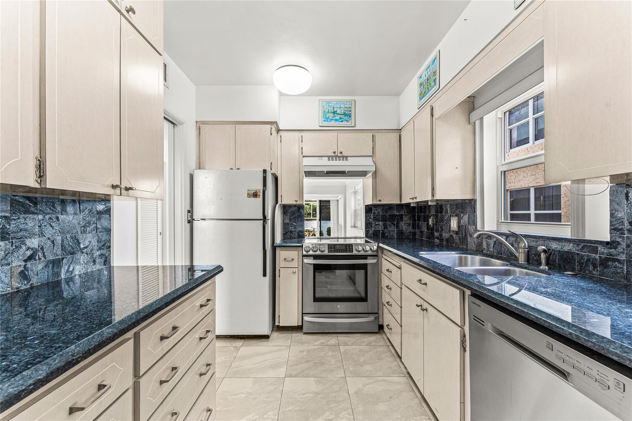 2758 Northeast 30th Avenue, Unit 1A Lighthouse Point, FL 33064 - Photo 5 of 48 a kitchen with stainless steel appliances granite countertop a refrigerator sink and cabinets