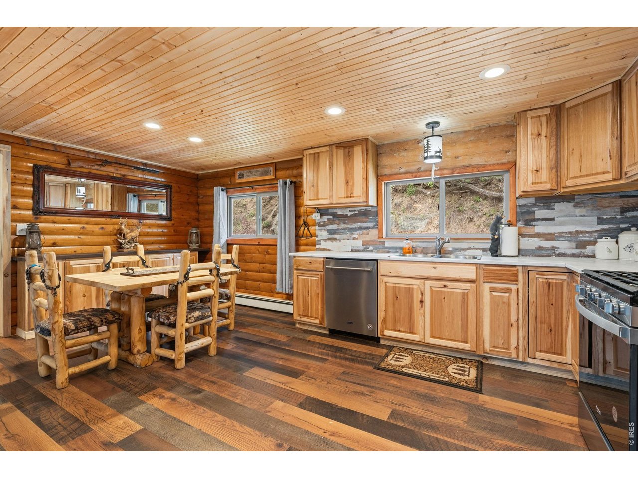 12743 Rist Canyon Road Bellvue, CO 80512 - Photo 14 of 49 a open kitchen with stainless steel appliances granite countertop a stove top oven a sink a dining table and chairs with wooden floor