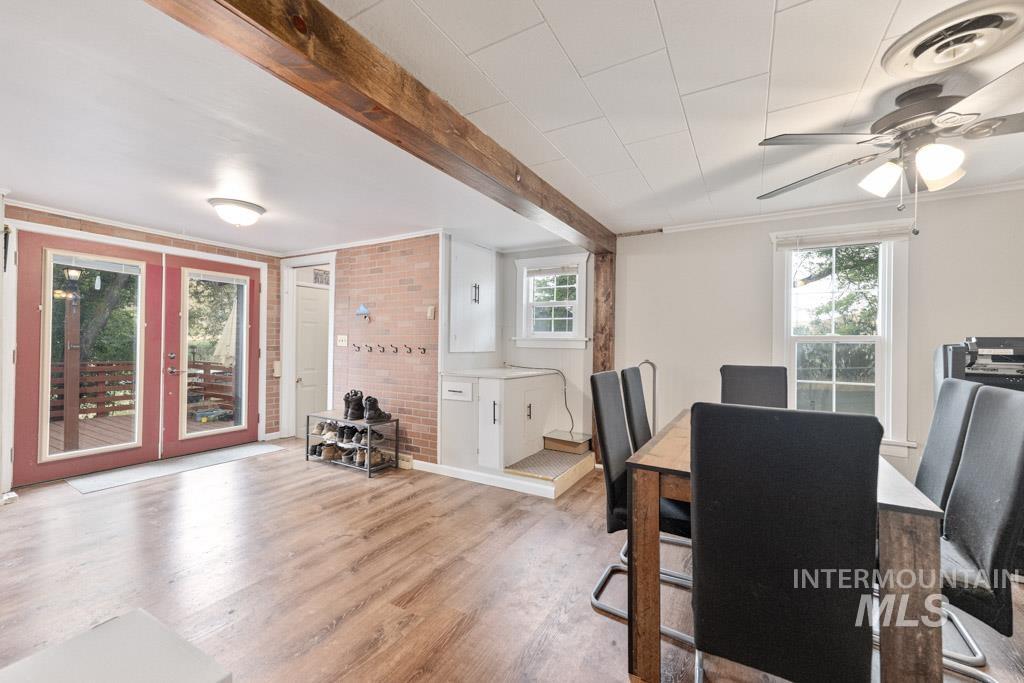 259 Highway 12 Pomeroy, WA 99347 - Photo 7 of 45 Wood-finish flooring throughout, featuring a natural wood beam, brick wall accent, and double glass-paneled doors
