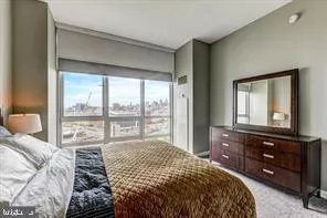 a bedroom with a bed and a large window