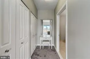 a view of a hallway with wooden floor and a dining room