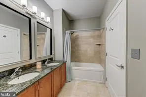 a bathroom with a granite countertop bathtub shower sink vanity and mirror