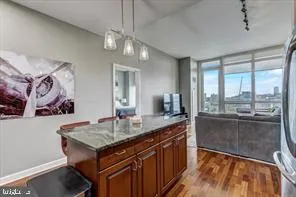 a dining hall with stainless steel appliances granite countertop a kitchen island a stove and a sink