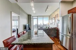 a kitchen with stainless steel appliances granite countertop a refrigerator a sink and a stove