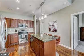 a kitchen with stainless steel appliances granite countertop a refrigerator a stove top oven a sink and dishwasher