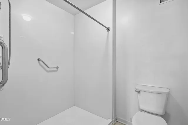 a bathroom with a toilet and a shower