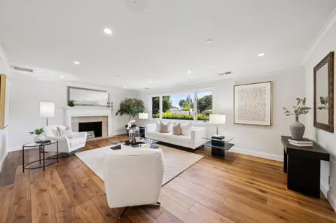 a living room with furniture a fireplace and a wooden floor