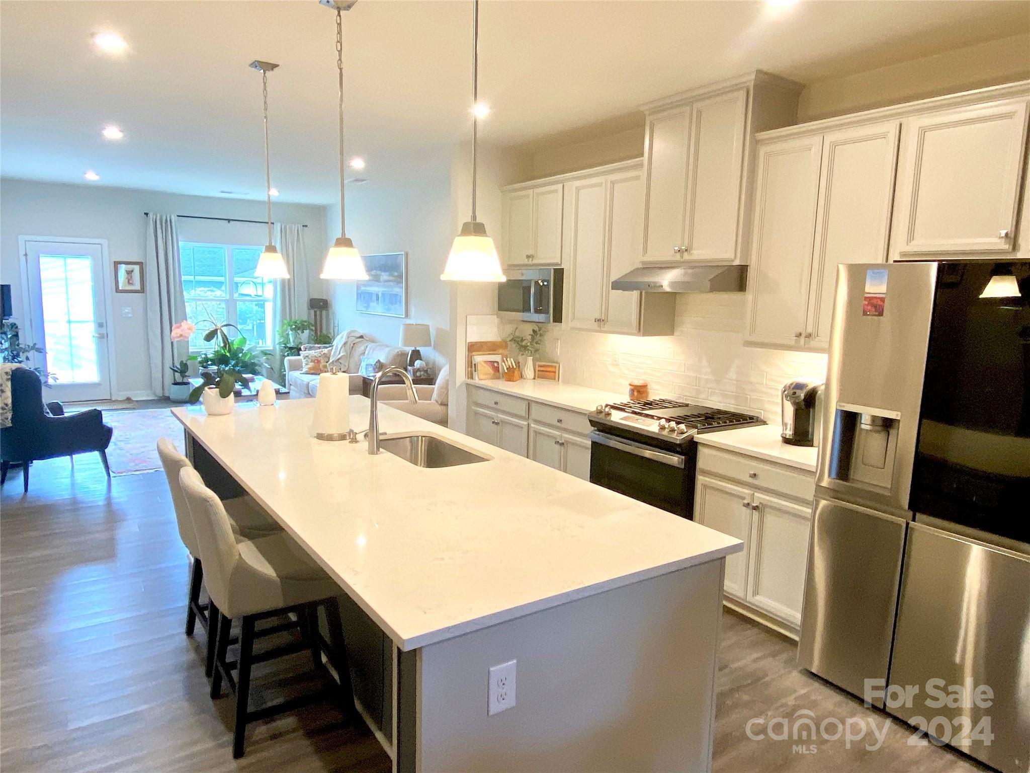 765 Hazel Way Denver, NC 28037 - Photo 3 of 35 a kitchen with stainless steel appliances a refrigerator a stove a sink a dining table and chairs