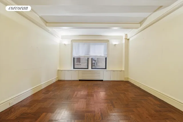 a view of empty room with a fireplace and wooden floor