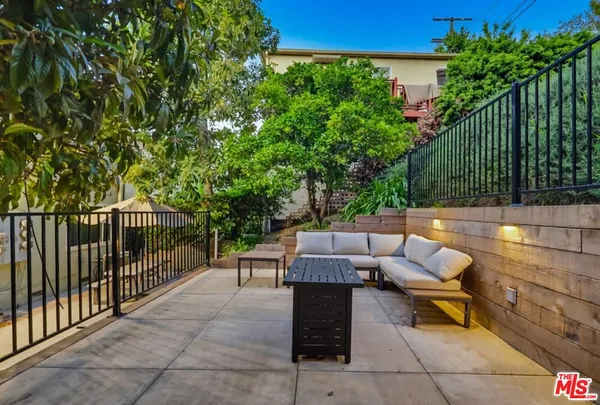 a view of a patio with couches and a large tree