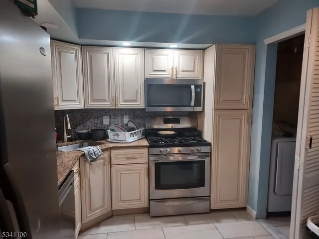 a kitchen with stove top oven and cabinets