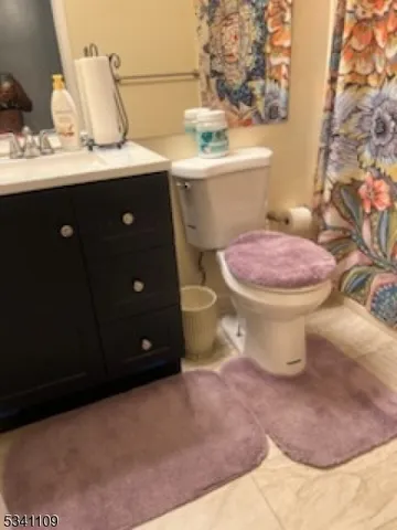 a bathroom with a granite countertop toilet sink and mirror