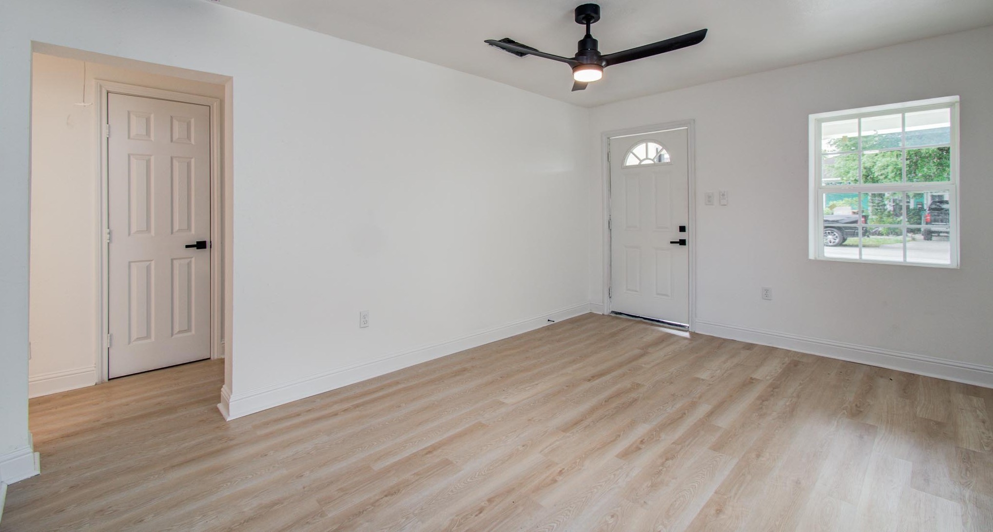 10309 Wiggins Street Houston, TX 77029 - Photo 6 of 32 an empty room with wooden floor ceiling fan and windows