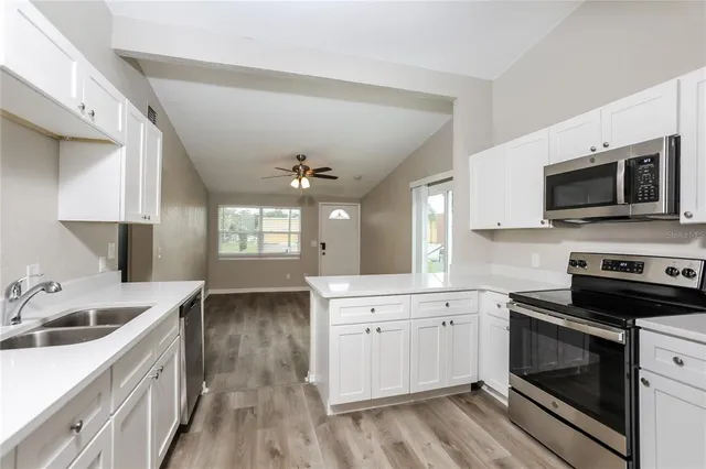 a kitchen with a sink stove and microwave