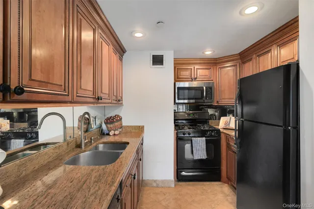 a kitchen with stainless steel appliances granite countertop a refrigerator and a sink