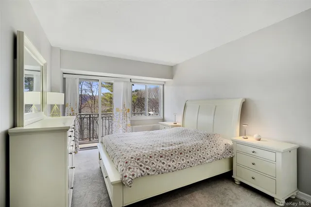 a bedroom with a bed and large windows