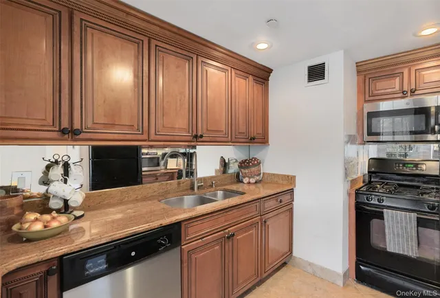 a kitchen with stainless steel appliances granite countertop a sink stove and microwave
