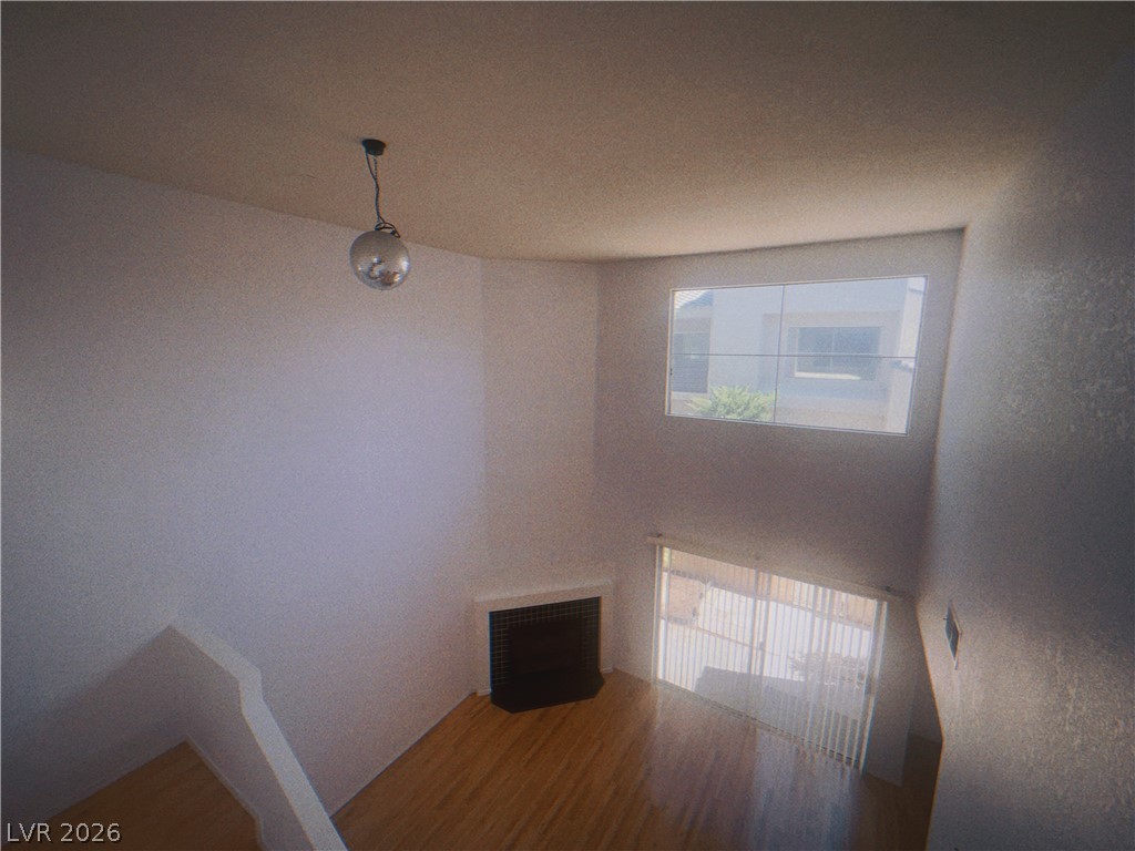 6250 West Flamingo Road, Unit 60 Las Vegas, NV 89103 - Photo 13 of 23 This living space features hardwood flooring and an integrated fireplace, offering a cozy and functional environment.