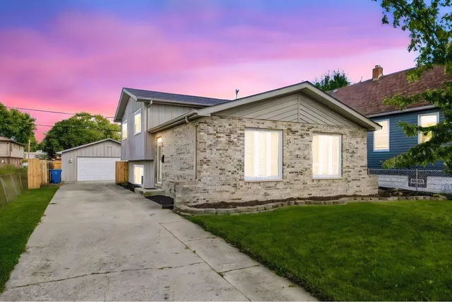 a front view of a house with a garden and yard