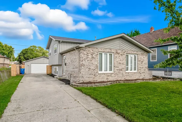 a front view of a house with a garden and yard