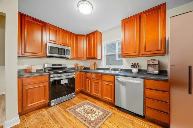 a kitchen with stainless steel appliances granite countertop a stove a sink and a microwave