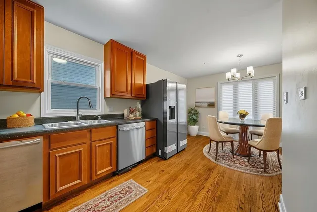 a kitchen with stainless steel appliances granite countertop a table chairs and a refrigerator