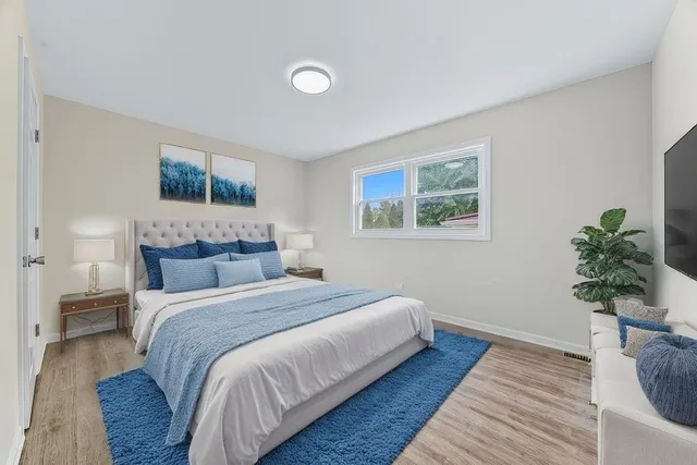 a bedroom with a bed and a potted plant