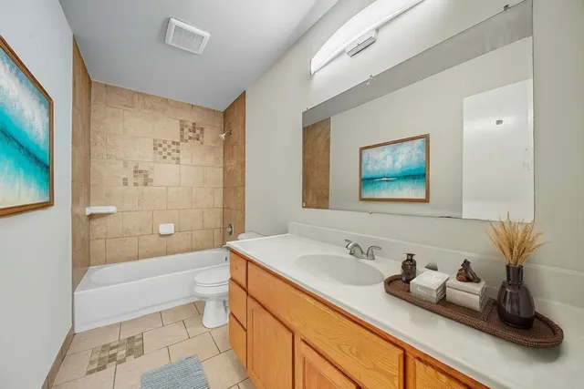 a bathroom with a granite countertop sink a mirror a bathtub and shower
