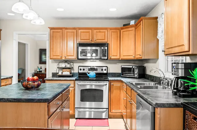 a kitchen with stainless steel appliances granite countertop a sink a stove and a microwave