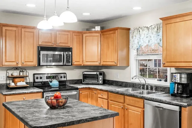 a kitchen with stainless steel appliances granite countertop a sink a stove and a microwave