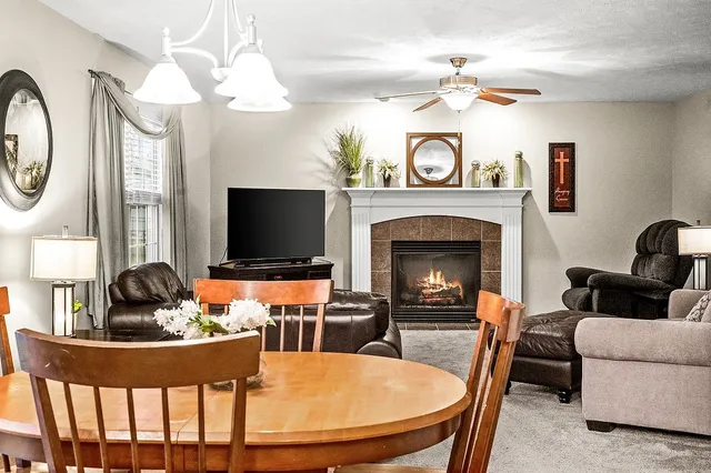 a living room with furniture a large window and a fireplace