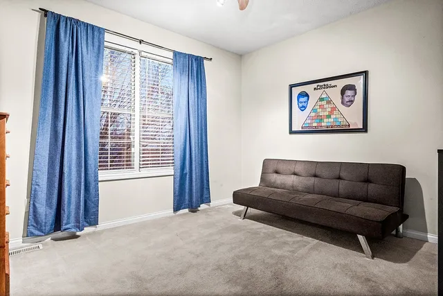 a spacious bedroom with a bed and a lamp