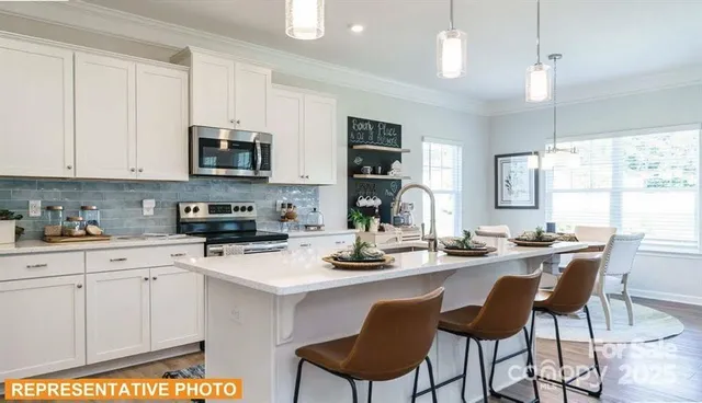 a kitchen with stainless steel appliances kitchen island granite countertop a sink counter space and windows