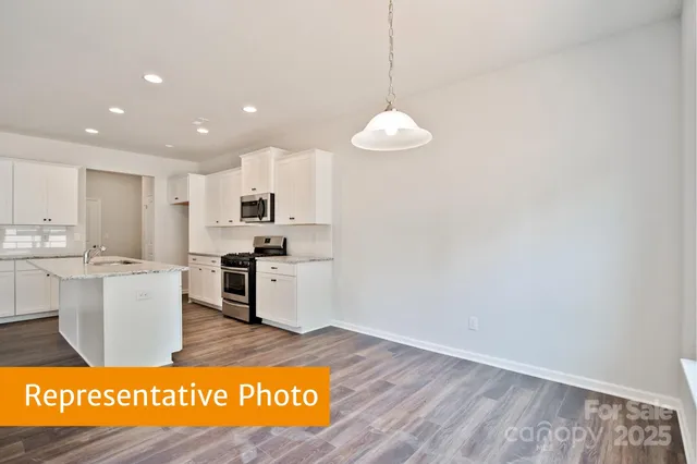 a kitchen with stainless steel appliances granite countertop a stove a sink and a refrigerator