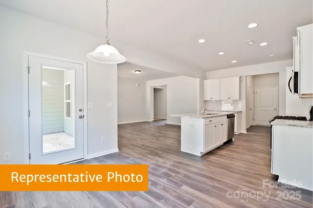 a view of kitchen with stainless steel appliances granite countertop cabinets and wooden floor