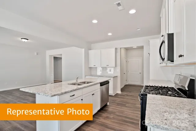 a kitchen with stainless steel appliances granite countertop a stove a sink and a refrigerator