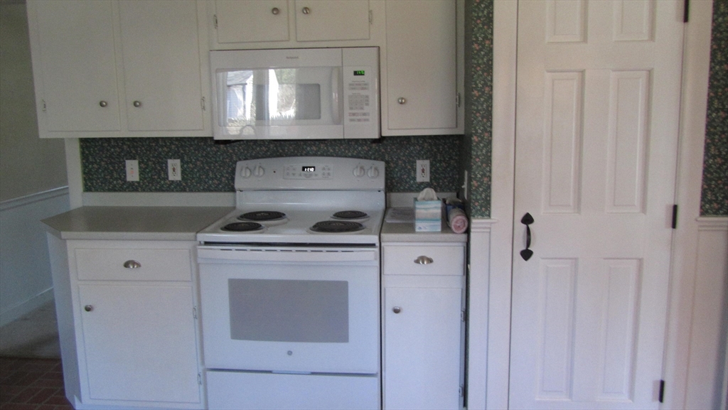 2 Bertha Street Hudson, MA 01749 - Photo 8 of 17 a kitchen with a stove and white cabinets