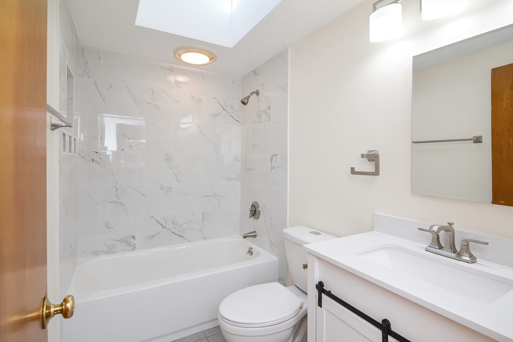 25 Indian Run Road Bellingham, MA 02019 - Photo 16 of 29 a bathroom with a granite countertop bathtub shower sink vanity mirror and toilet